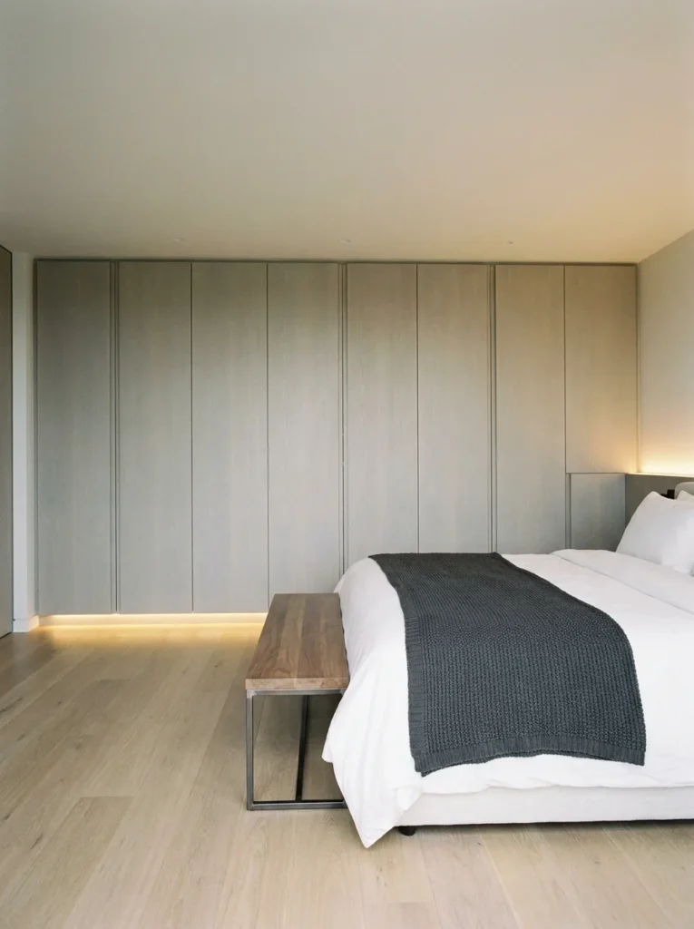 A minimalist bedroom layout planner design featuring a wall of sleek wardrobes facing the bed for maximum storage.